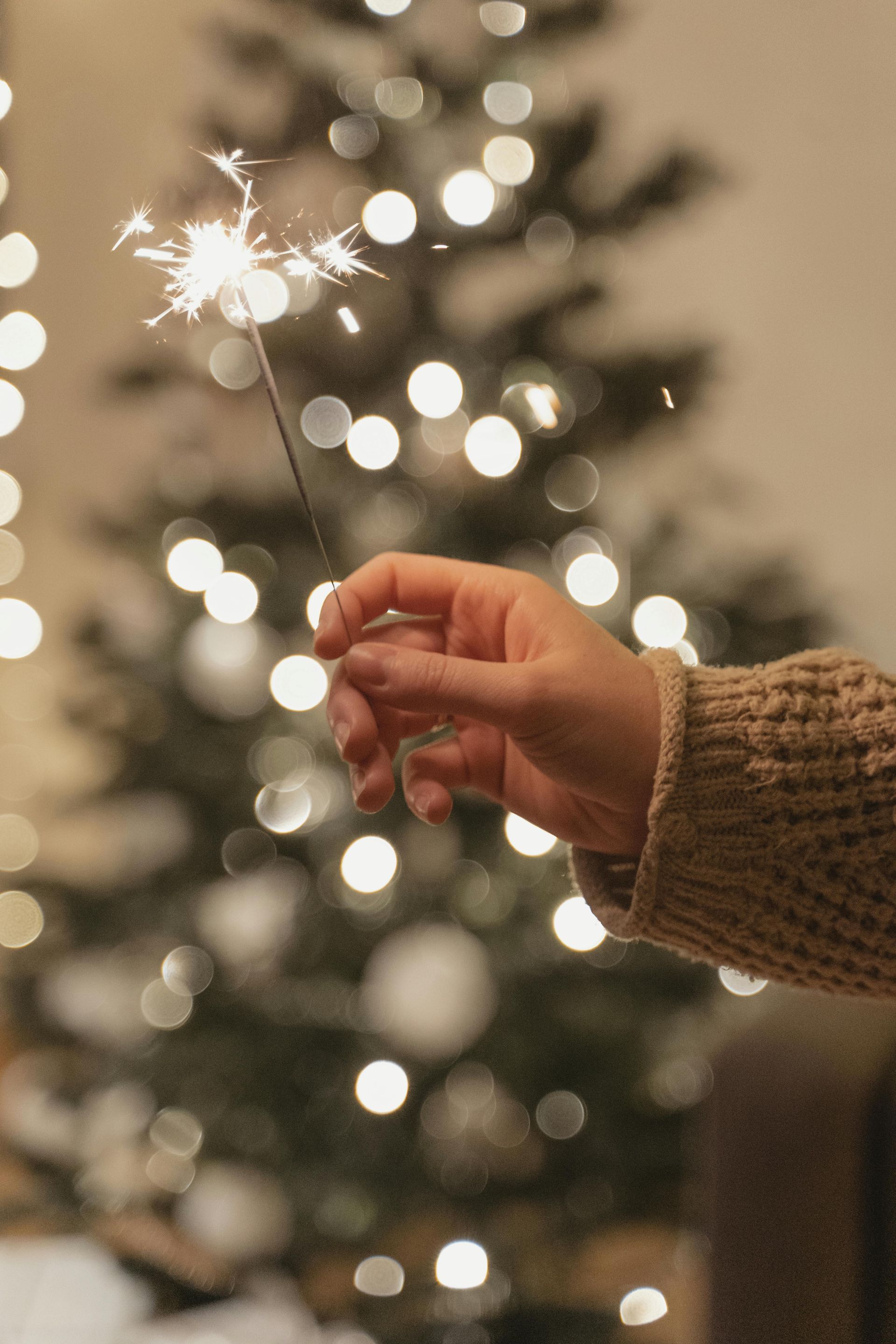 Wunderkerze vor einem Weihnachtsbaum