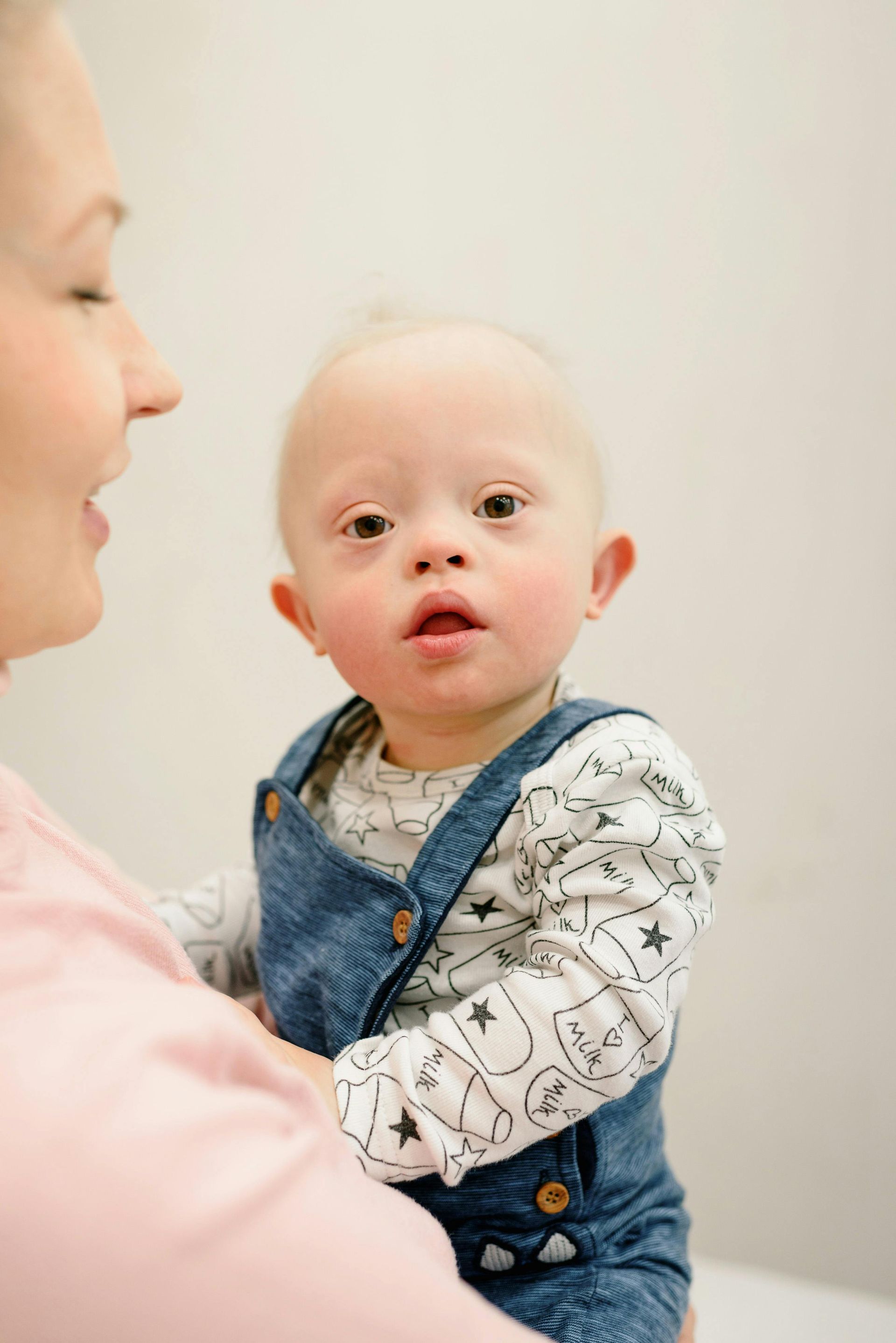 Mutter hat ein Kind mit Down-Syndrom auf dem Arm