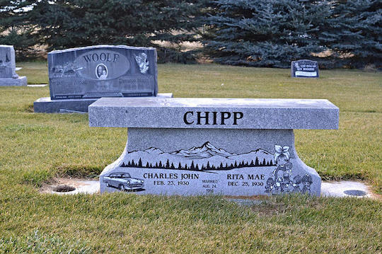 Grave marker in a cemetery with a bench-like top and the name 
