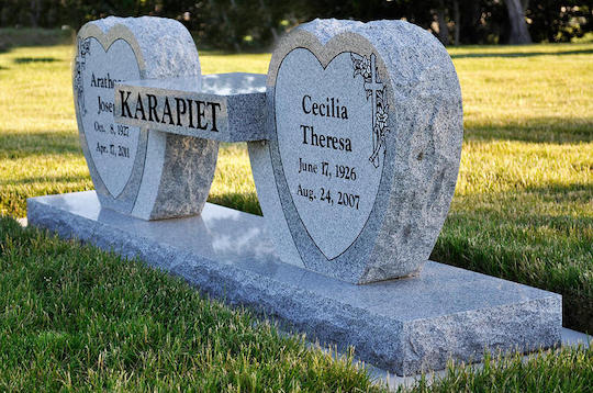 Gravestone with two heart-shaped sections, names and dates inscribed.