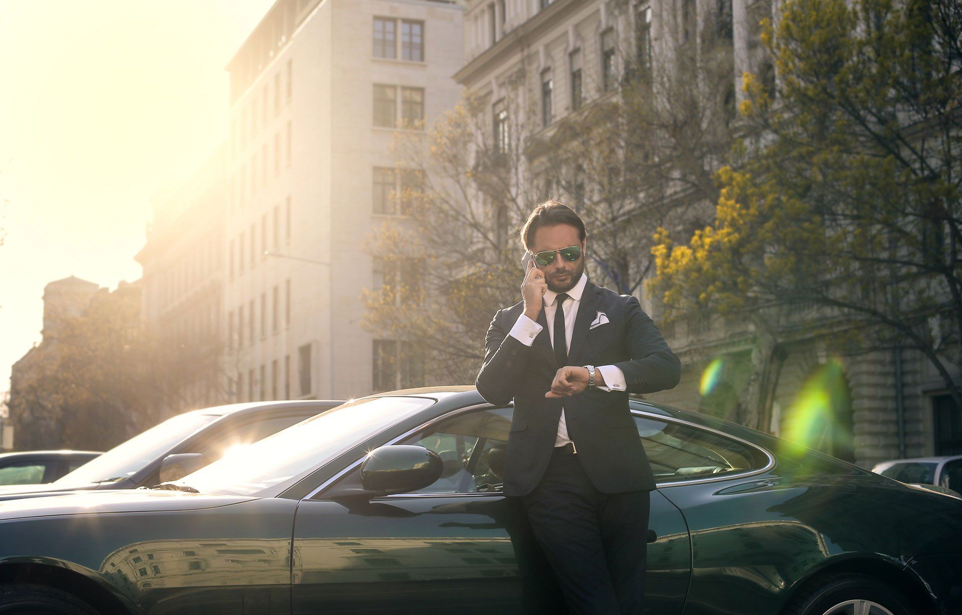 man standing near a luxury car