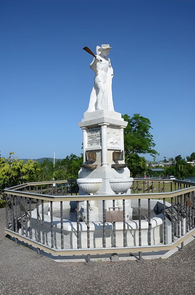 A Statue Of A Woman Holding A Cross Is Surrounded By A Fence — Gori Marble & Granite Pty Ltd in Earlville, QLD