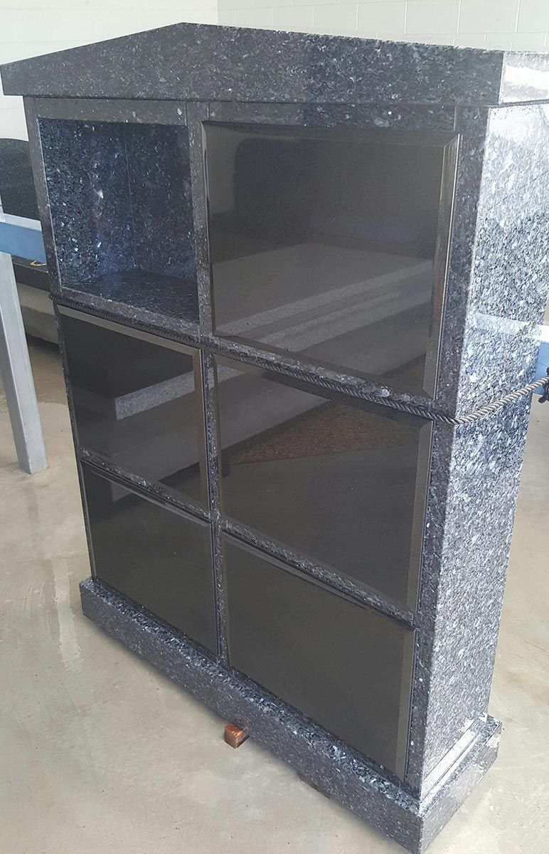 A Black Shelf With Glass Doors is Sitting on a Table — Gori Marble & Granite Pty Ltd in Tablelands, QLD