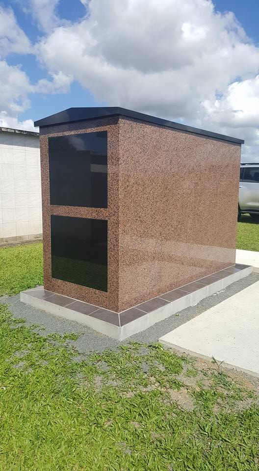 A Small Mausoleum is Sitting in the Middle of a Grassy Field — Gori Marble & Granite Pty Ltd in Tully, QLD