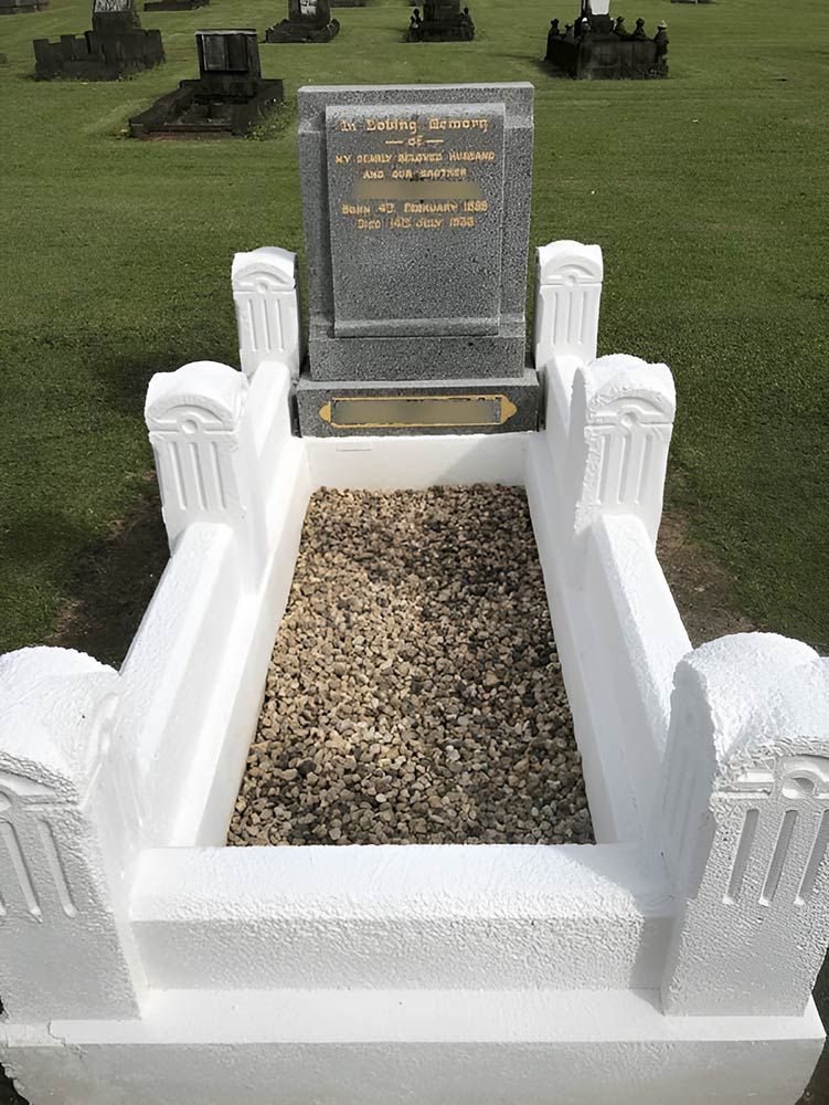 A Grave In A Cemetery With Gravel And A White Fence — Gori Marble & Granite Pty Ltd in Earlville, QLD
