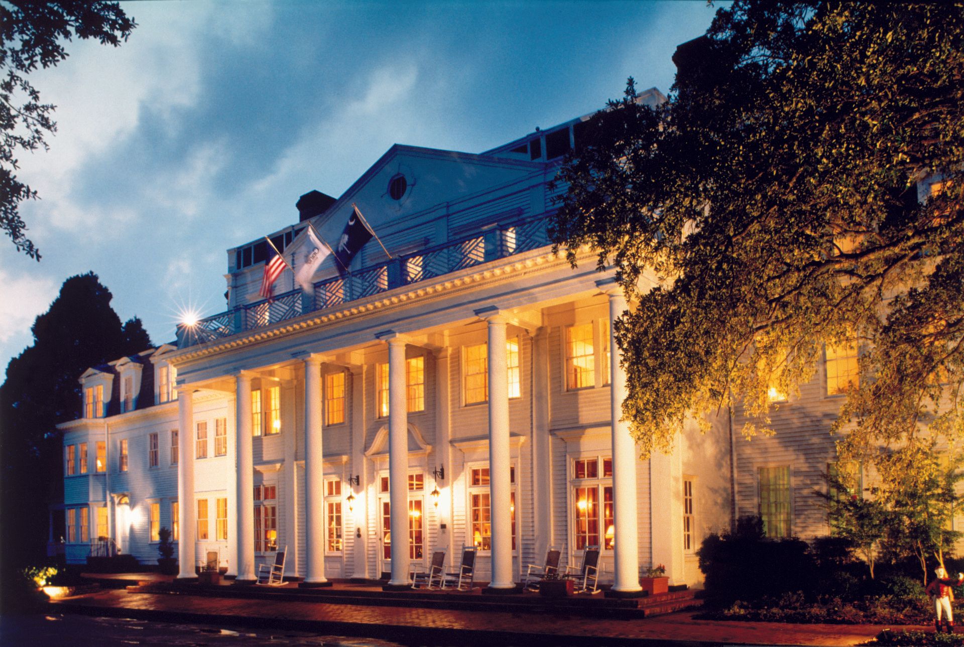 A large white building with columns is lit up at night