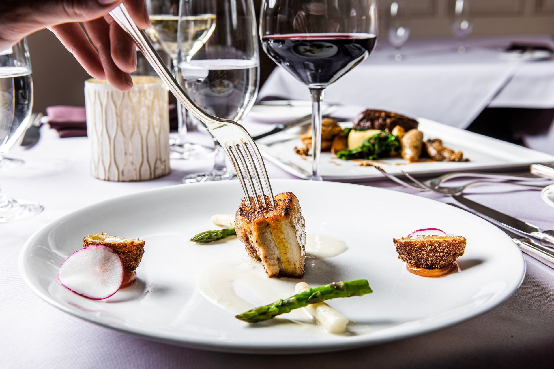 A person is holding a fork over a plate of food.