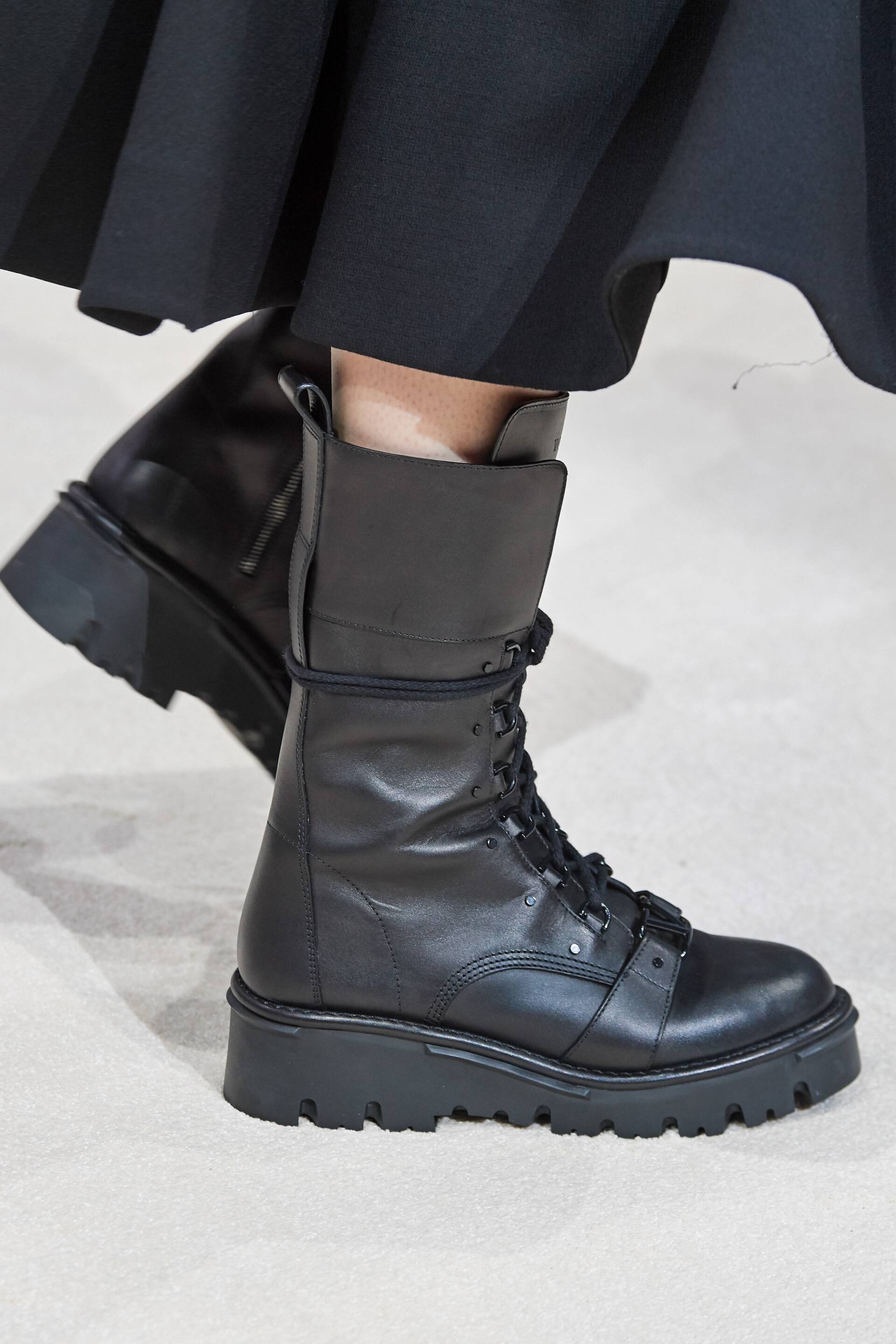 A close up of a person wearing a pair of black boots