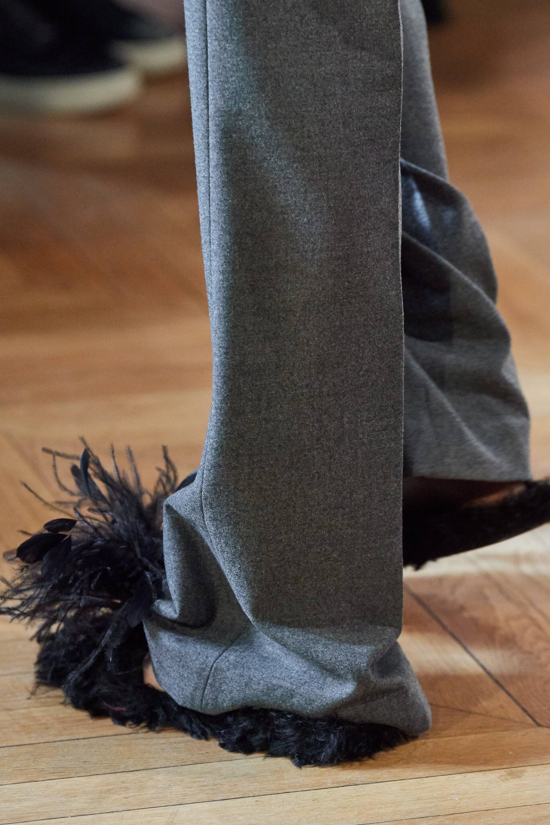 A close up of a person wearing a pair of pants with feathers on them.