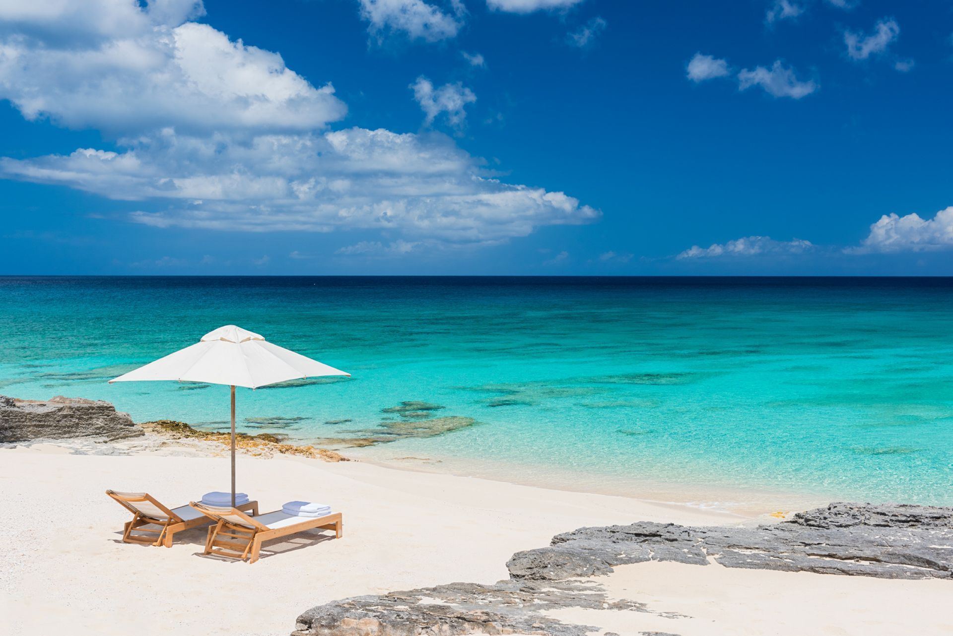 There is an umbrella and chairs on the beach.
