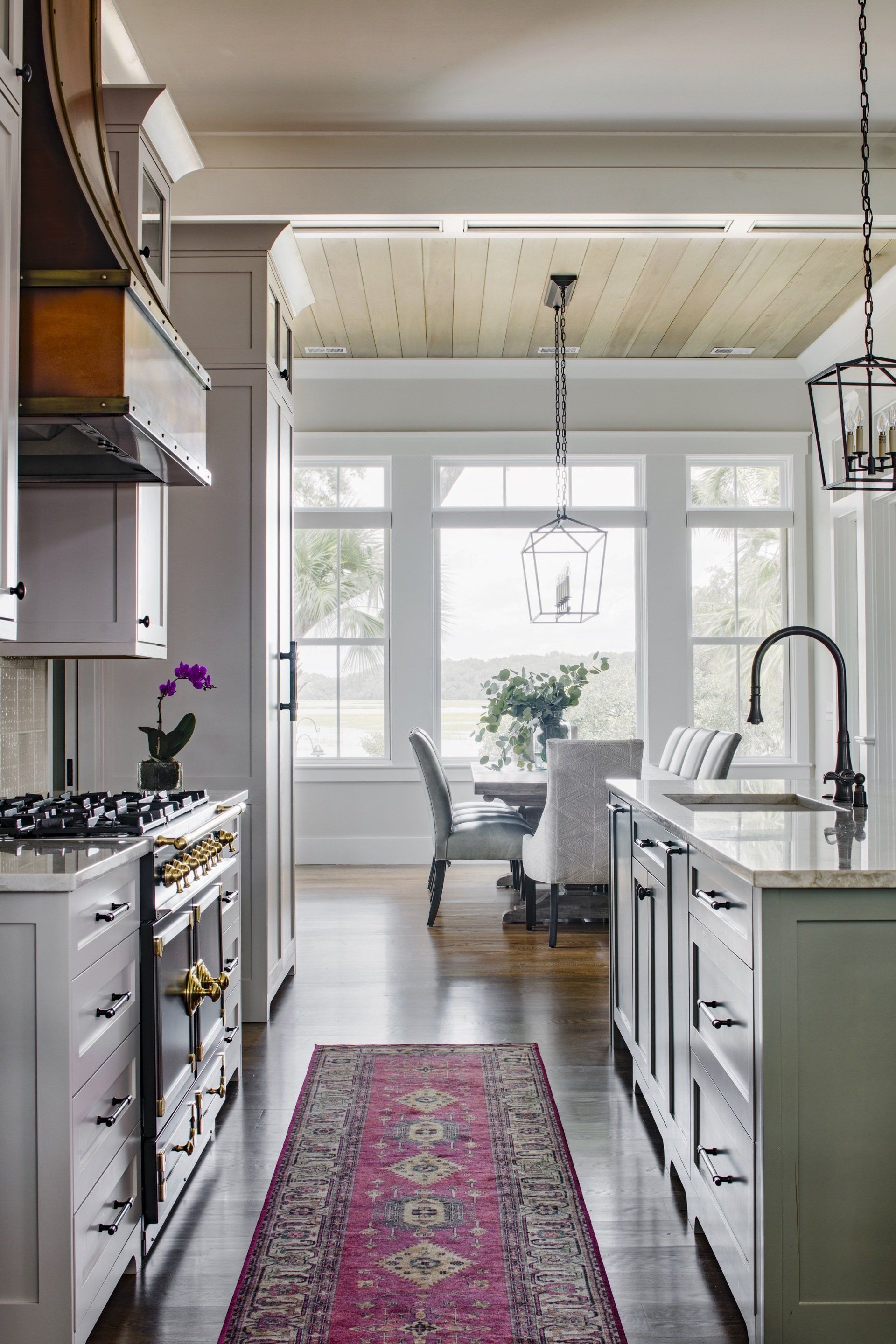 A kitchen with a long hallway leading to a dining room.