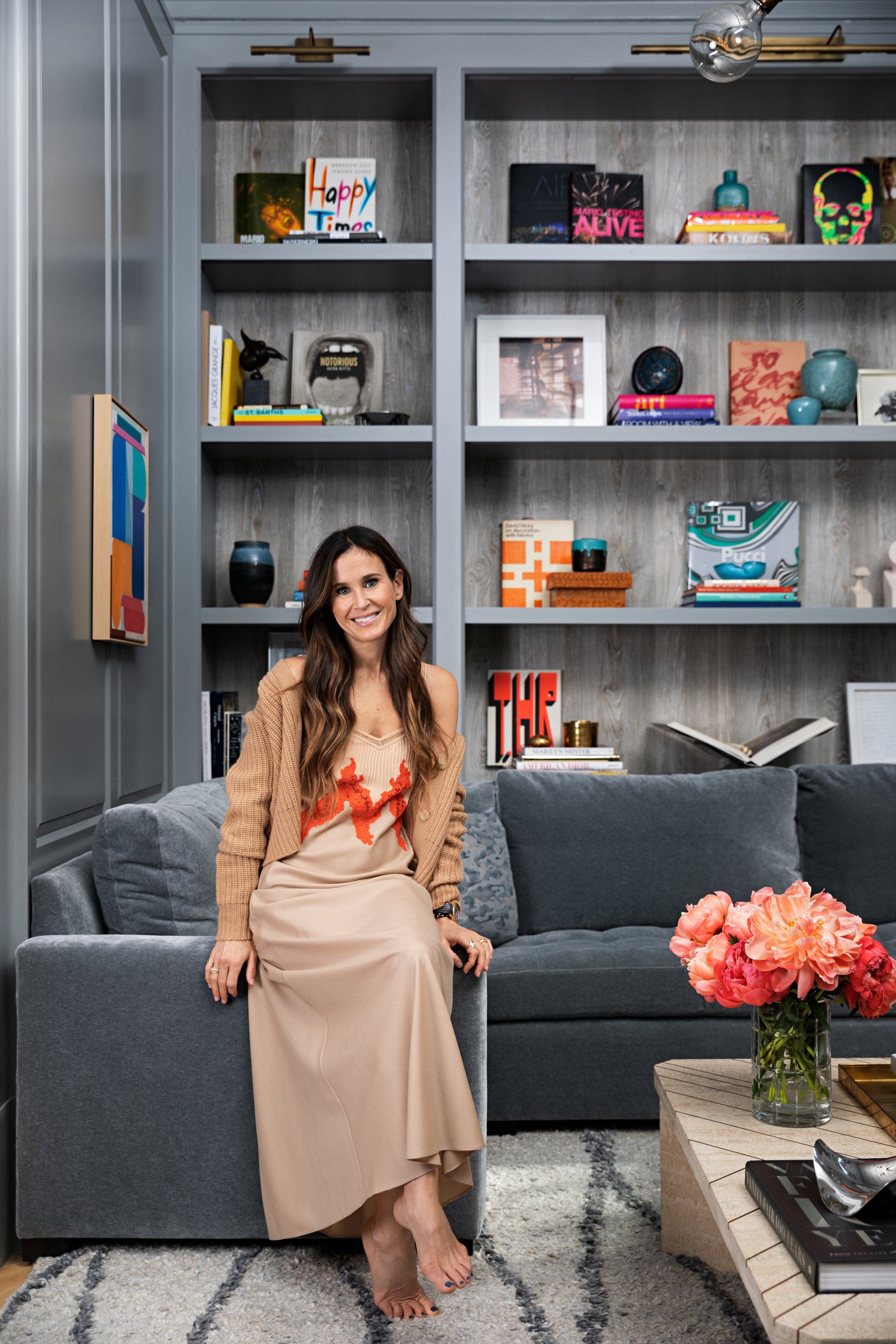 A woman is sitting on a couch in a living room.