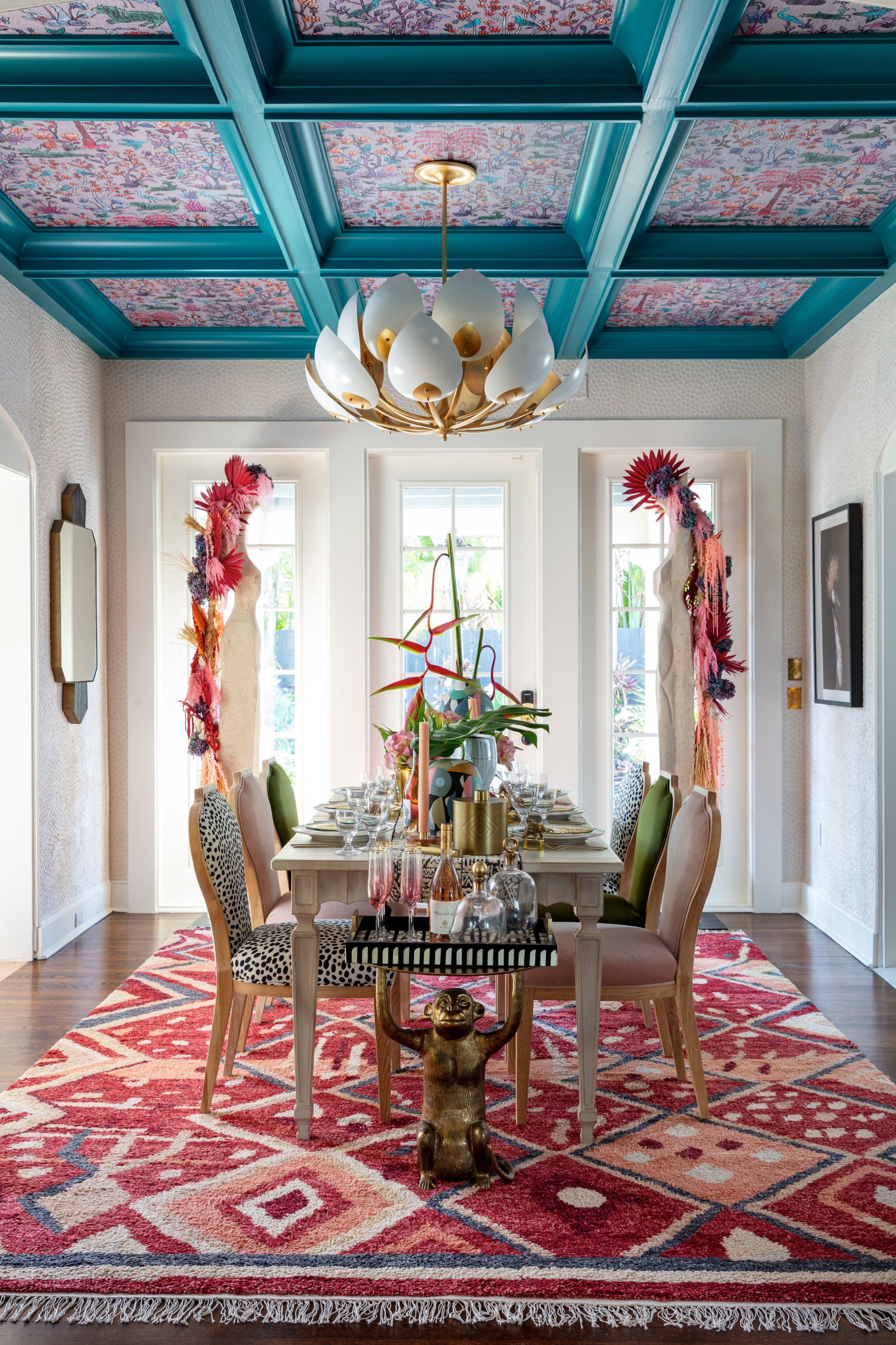 A dining room with a table and chairs and a blue ceiling.