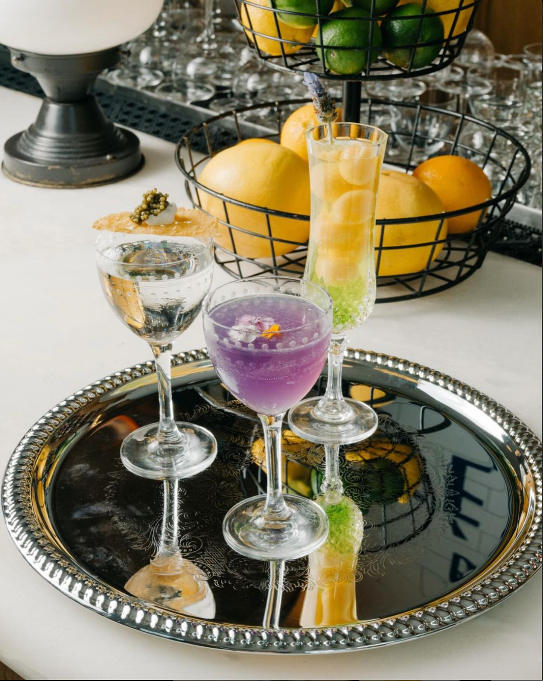 A silver tray with a variety of drinks on it.