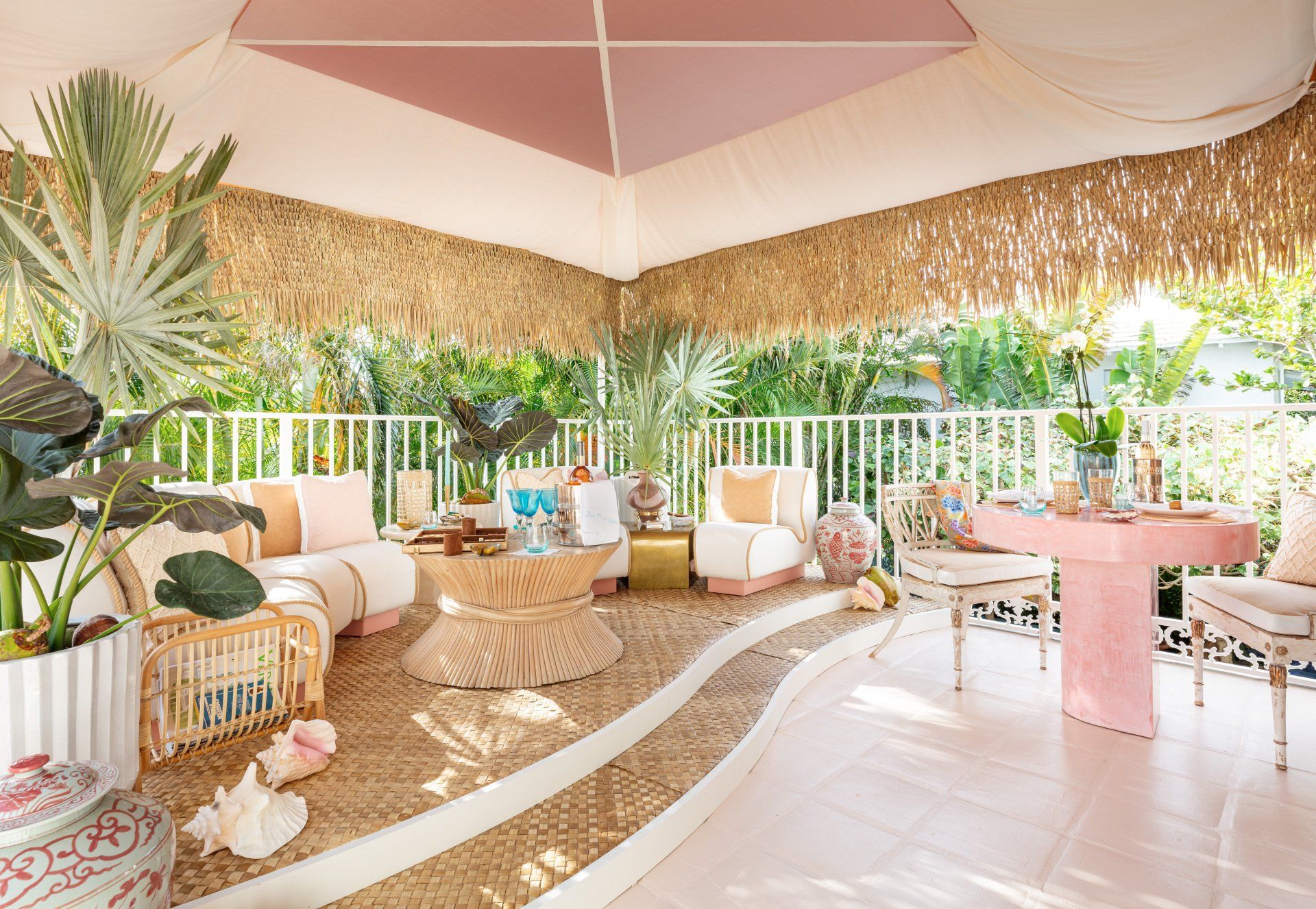 A living room with a table , chairs , and a thatched roof.