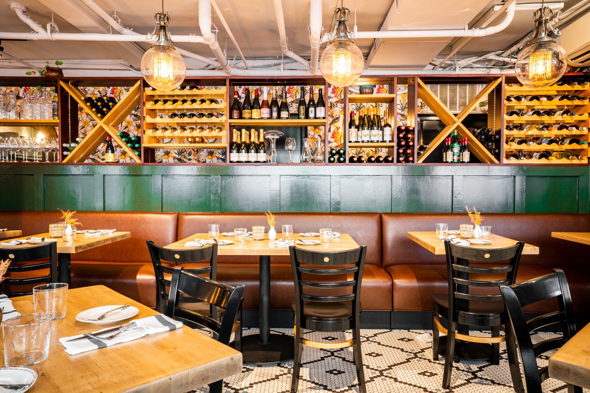 A restaurant with tables and chairs and a wine rack on the wall.