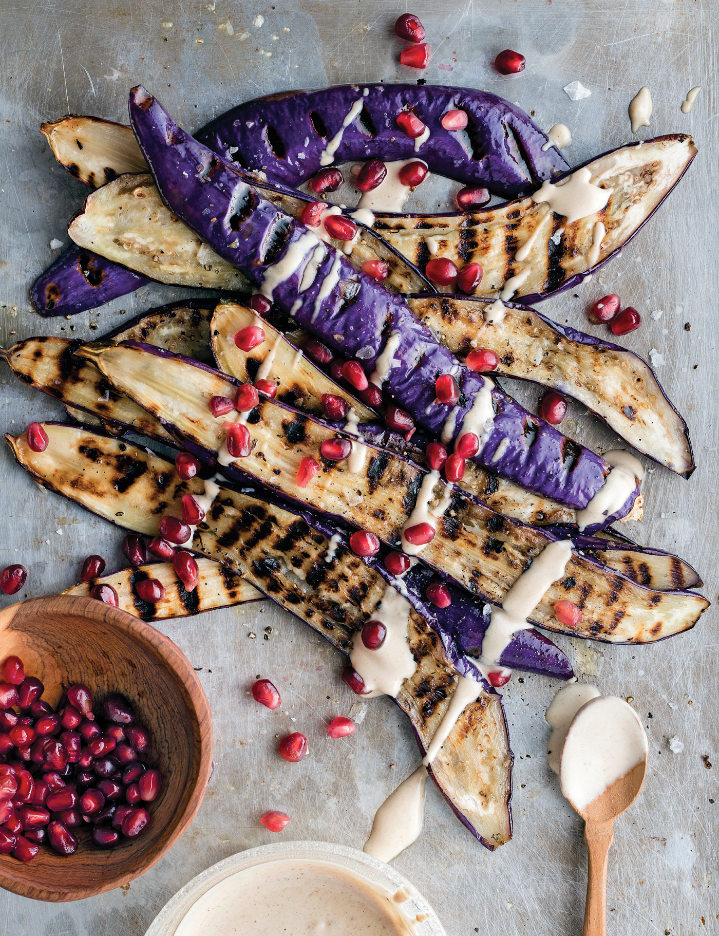 Grilled eggplant with sauce and pomegranate seeds on a table