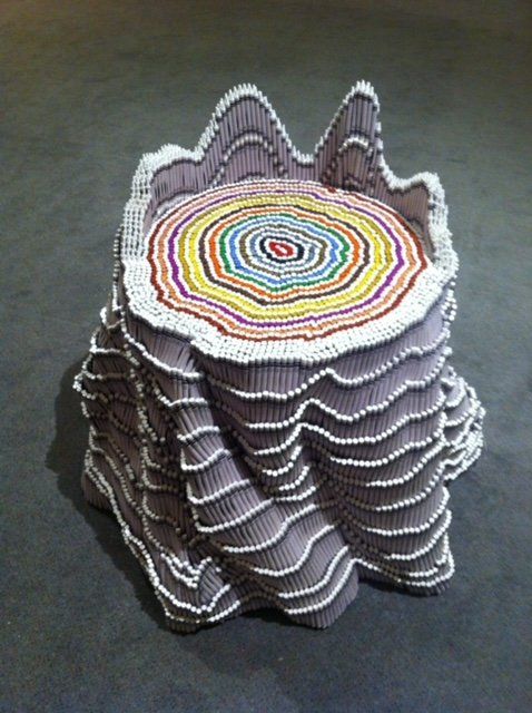 A stack of crocheted coasters with a rainbow colored center