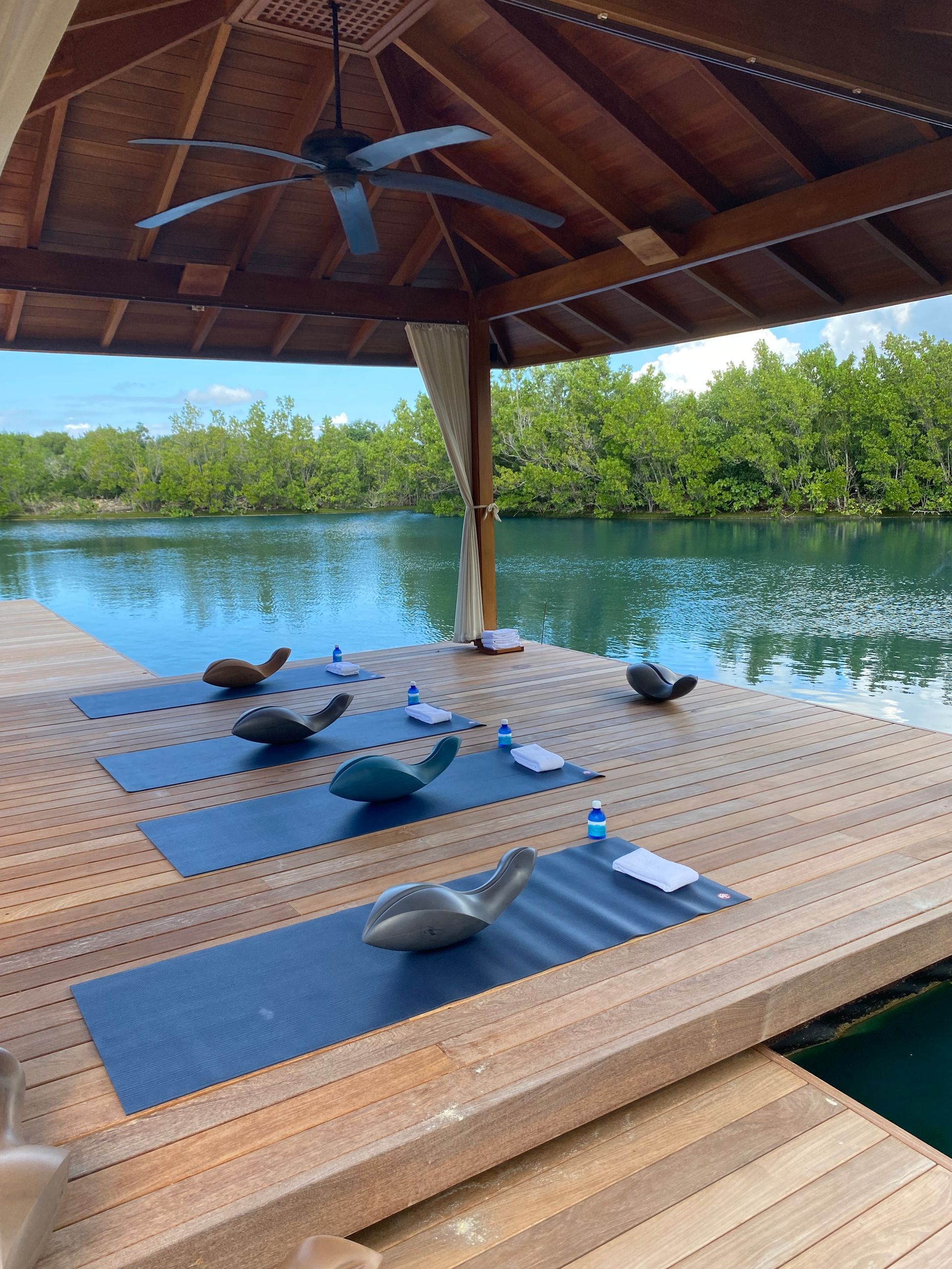 A row of yoga mats on a dock overlooking a body of water