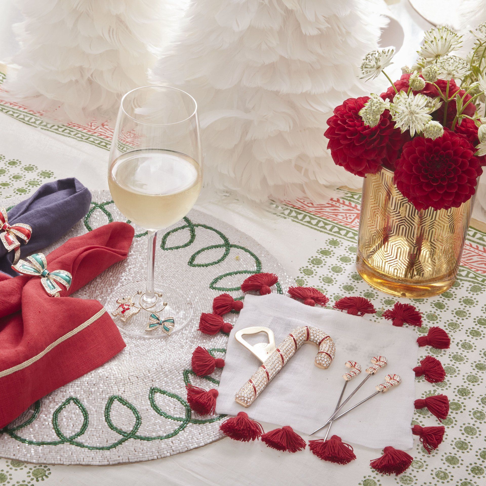 A table with a vase of flowers and a glass of wine