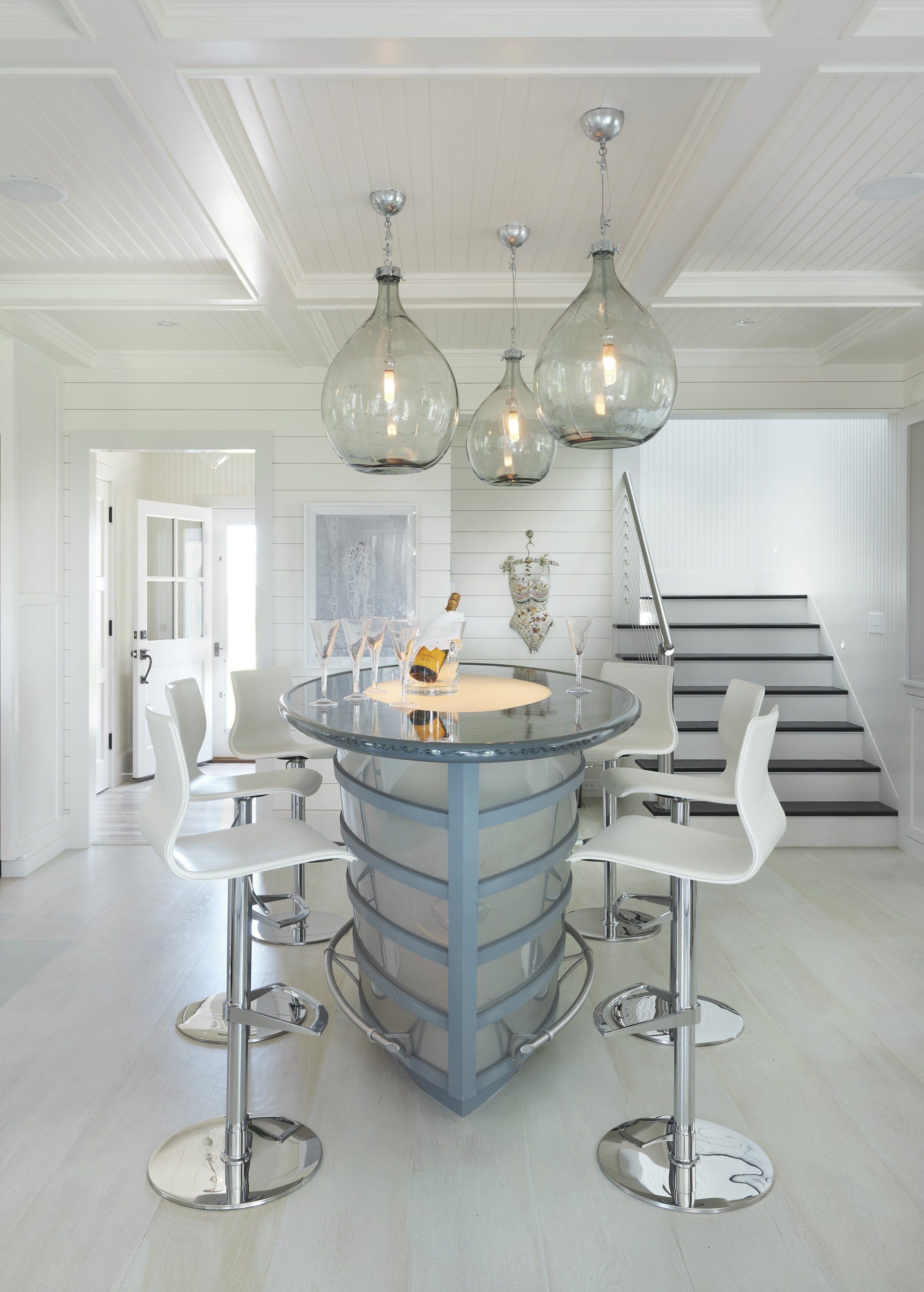 A kitchen with a boat shaped bar and stools