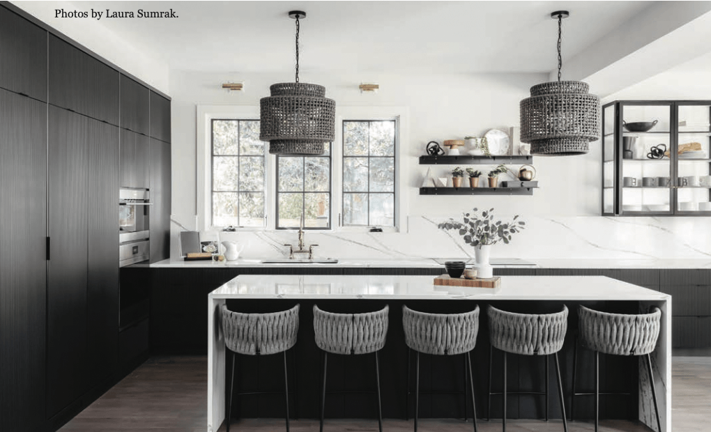 A black and white kitchen with a large island and stools.