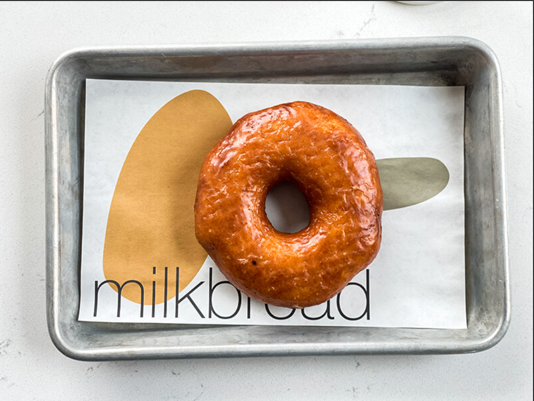 A donut is sitting on a tray that says milkbread