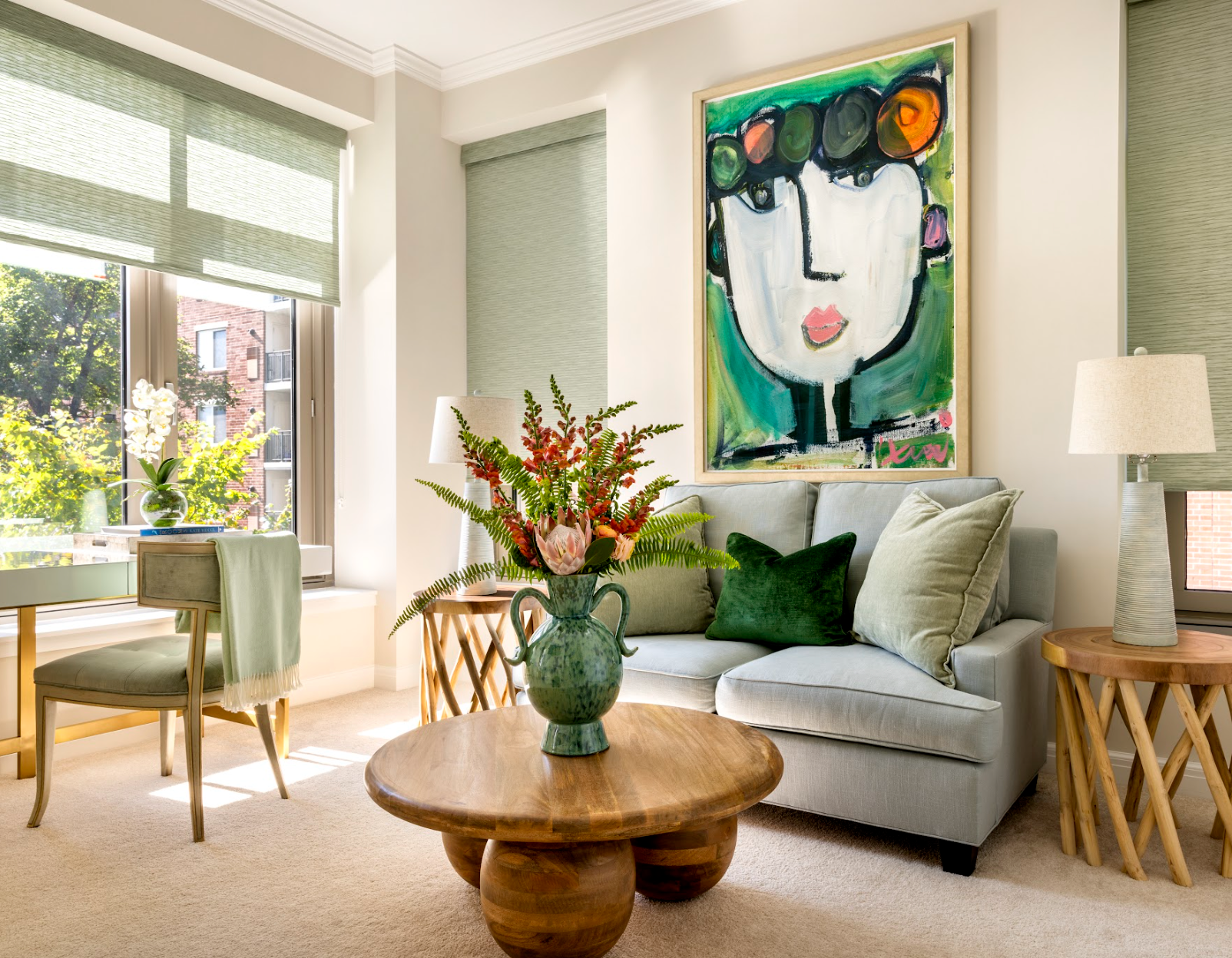 A living room with a couch , table , chairs and a painting on the wall.