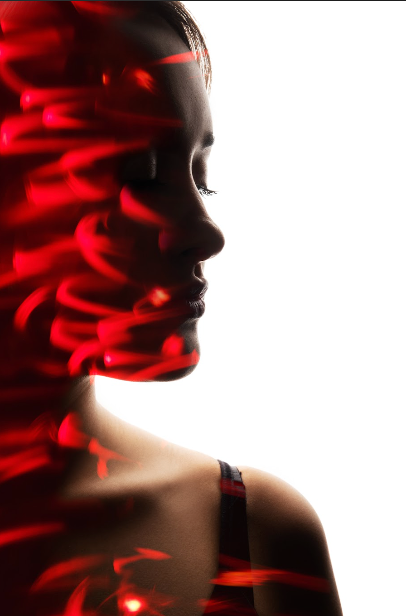 A woman with red lights projected on her face