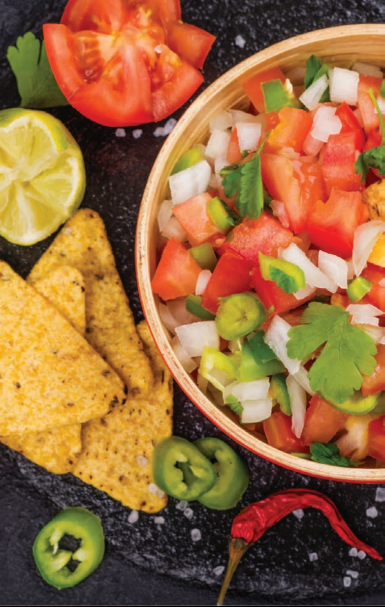 There is a bowl of salsa next to a bowl of tortilla chips.