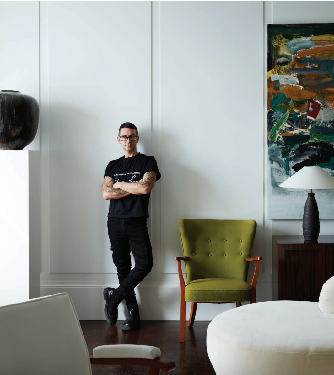 A man standing in a living room with his arms crossed