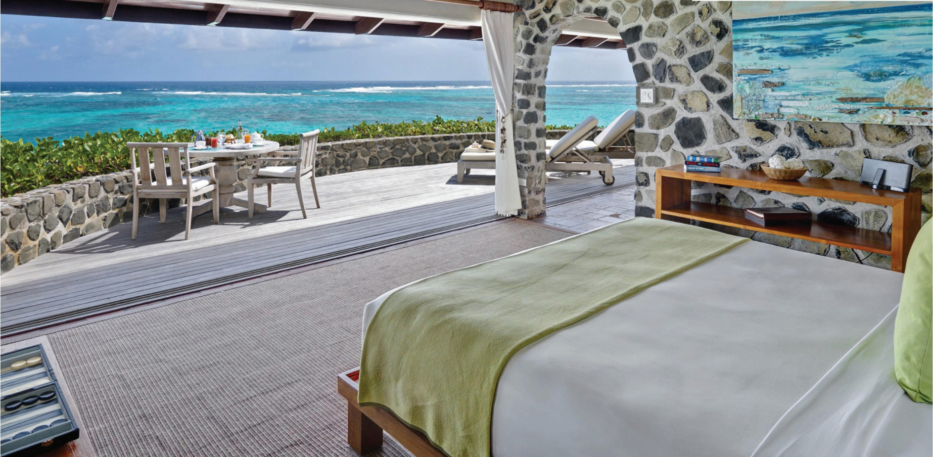 A hotel room with a large bed and a view of the ocean.