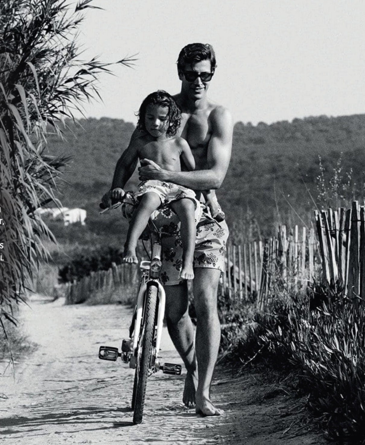 A man is carrying a child on his back while riding a bike