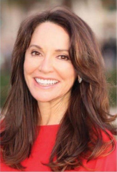 A woman with long brown hair is wearing a red shirt and smiling