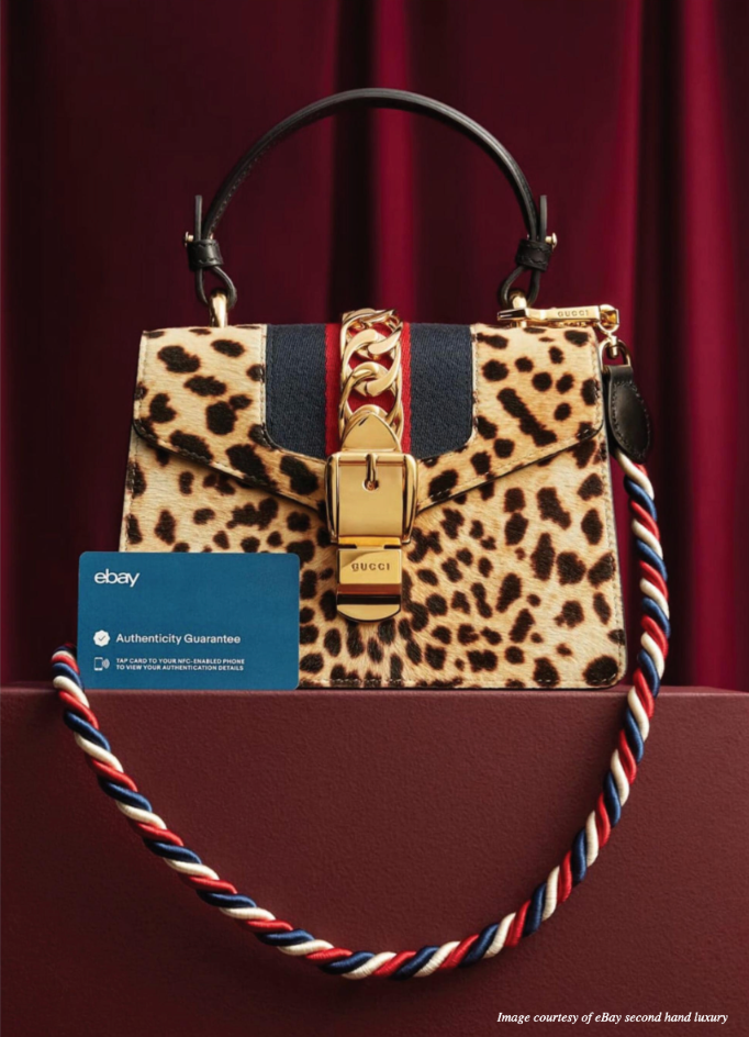 A leopard print purse with a card that says ebay on it