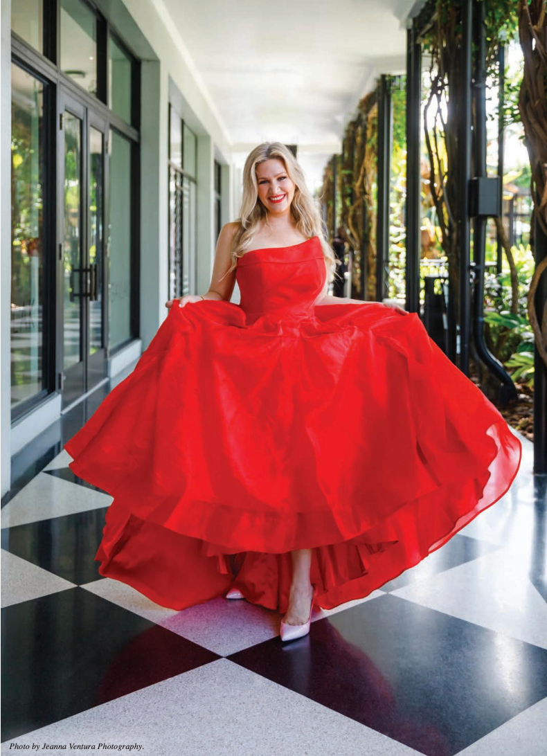 A woman in a red dress is standing in a hallway.