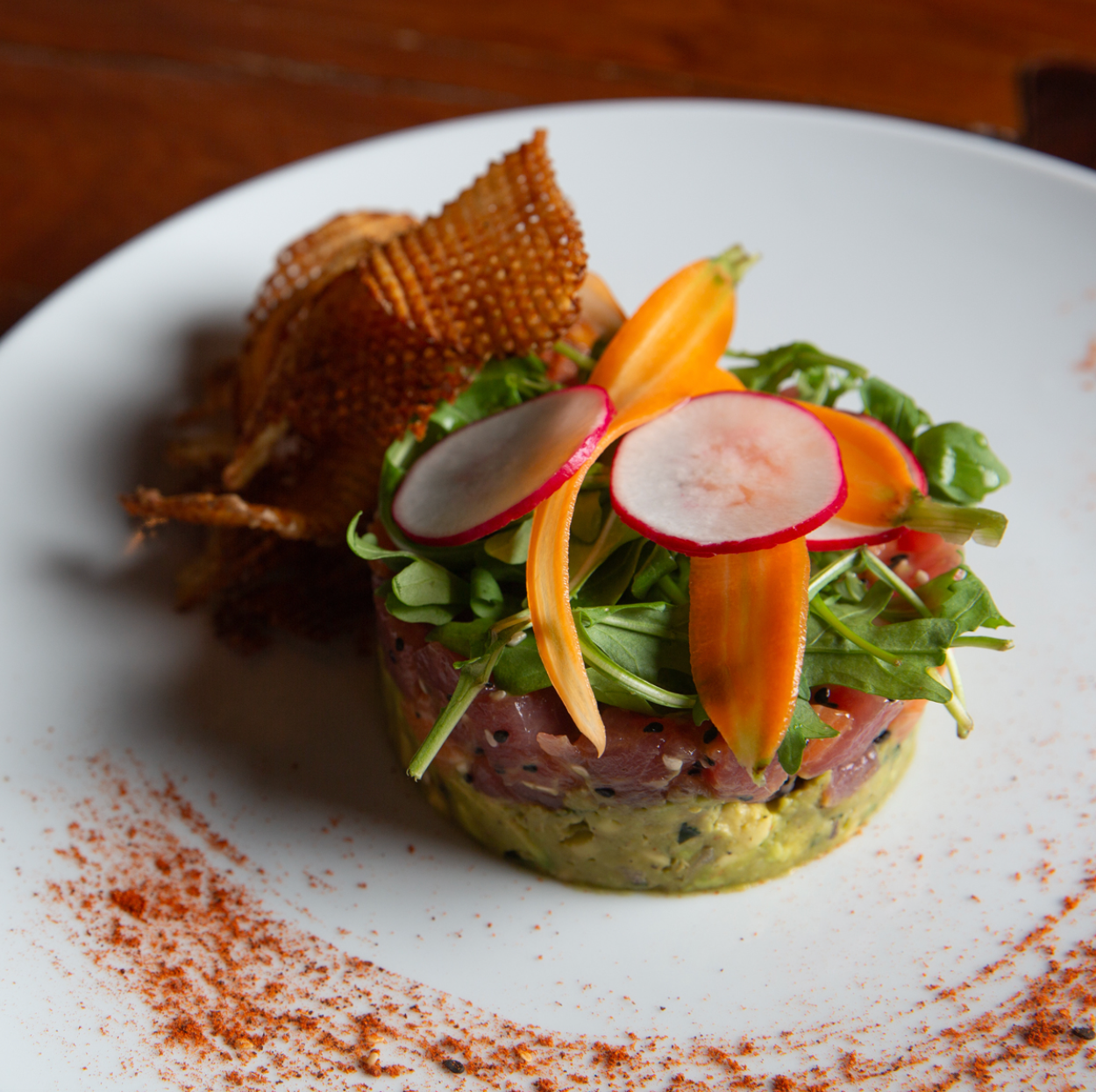 A white plate topped with a salad with radishes and carrots