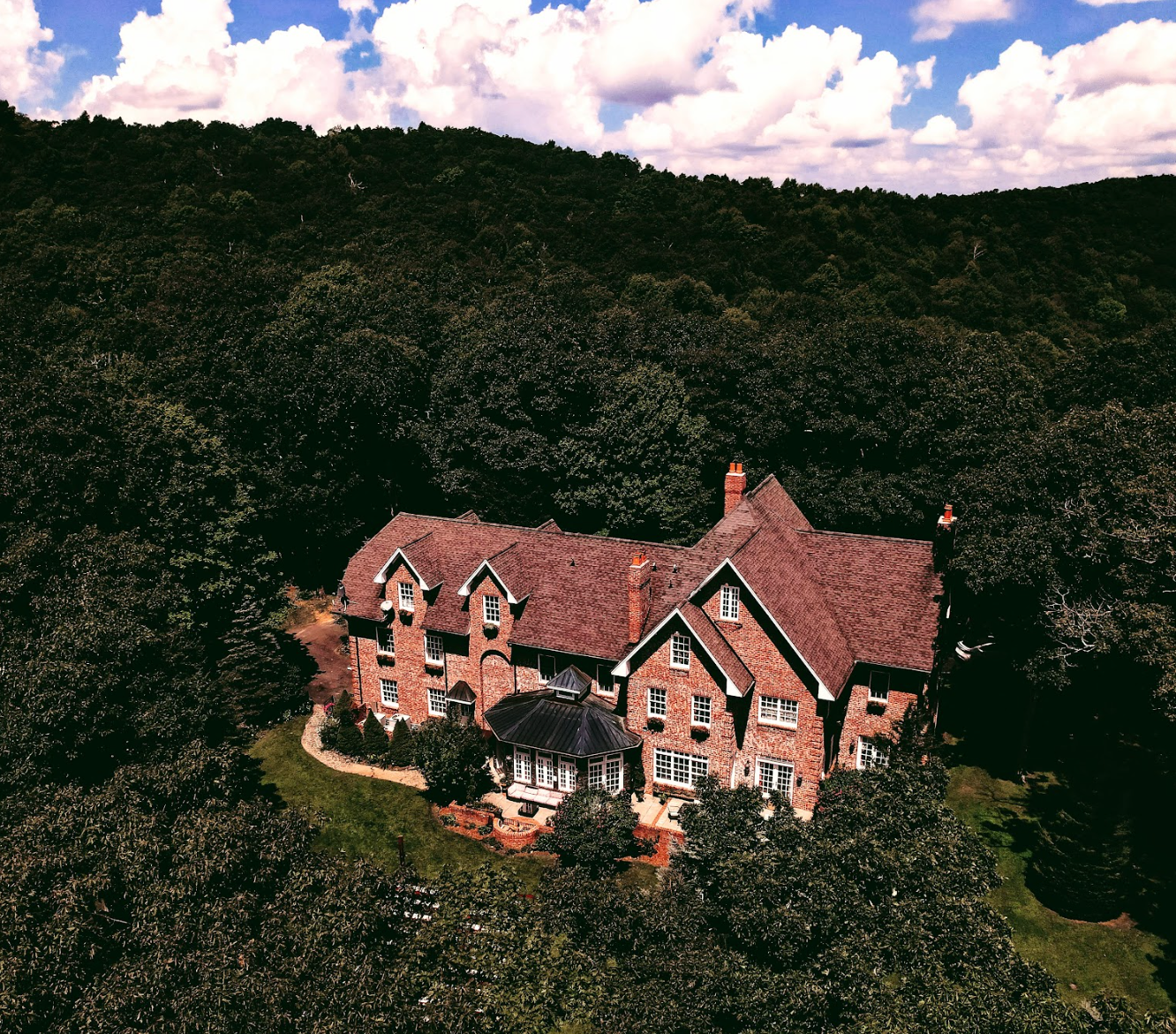 An aerial view of a large house surrounded by trees