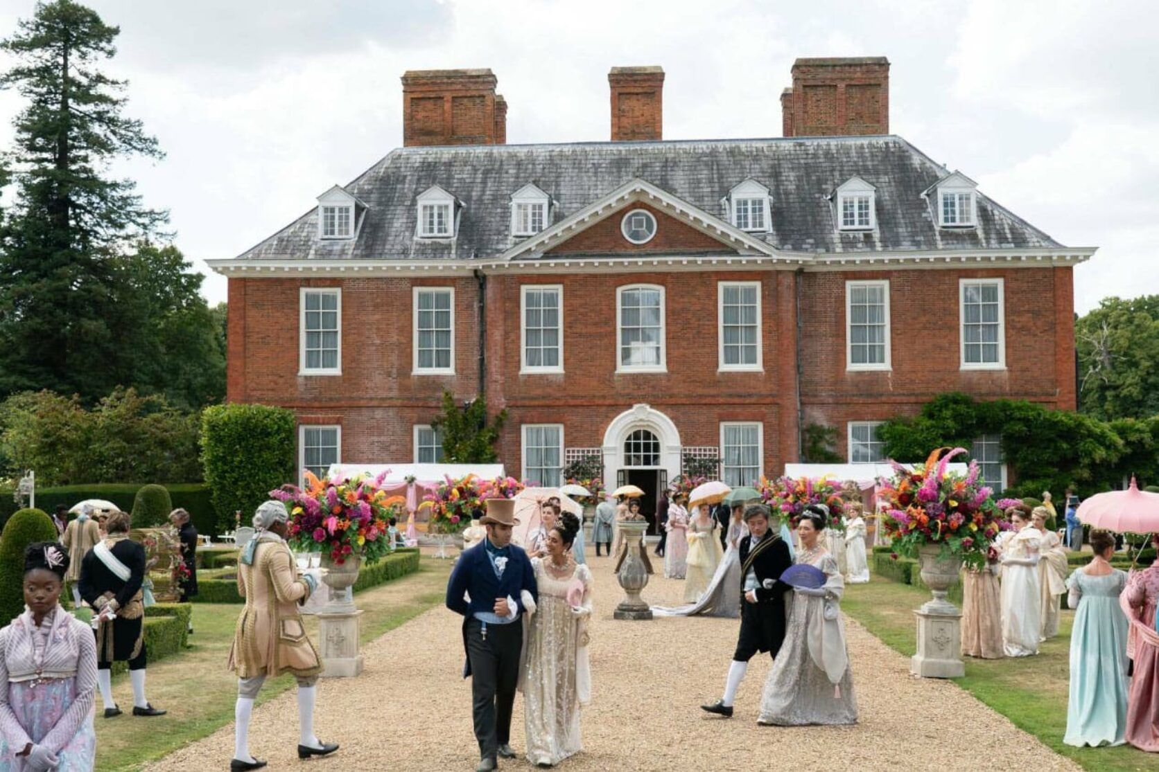 A group of people are standing in front of a large brick building.