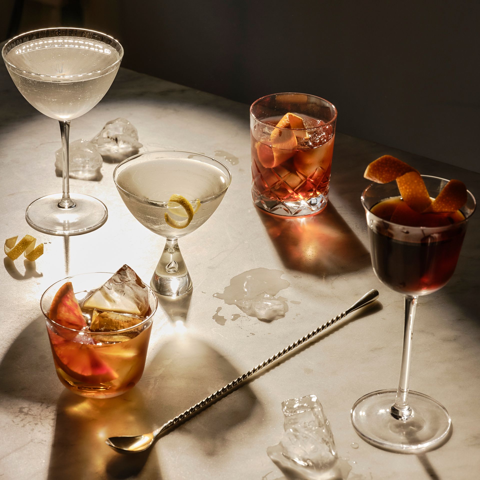 A table topped with a variety of drinks including a martini