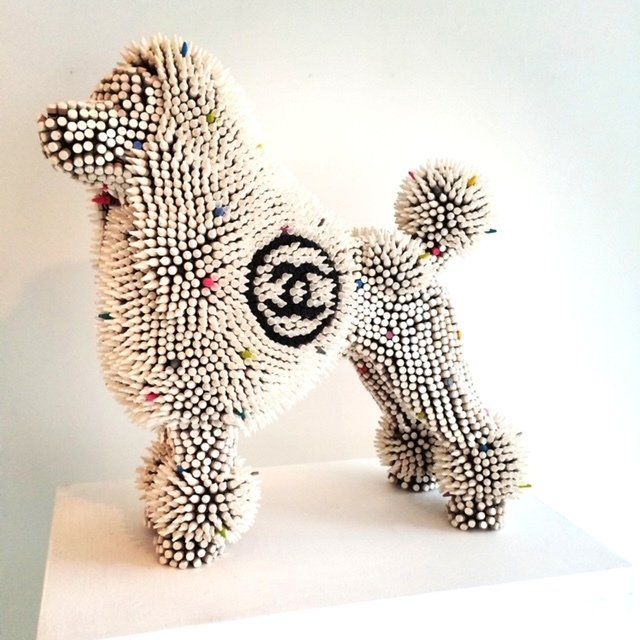 A sculpture of a poodle with a chanel logo on its back