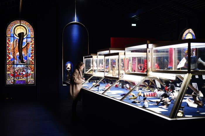 A woman is looking at a display case in a museum.