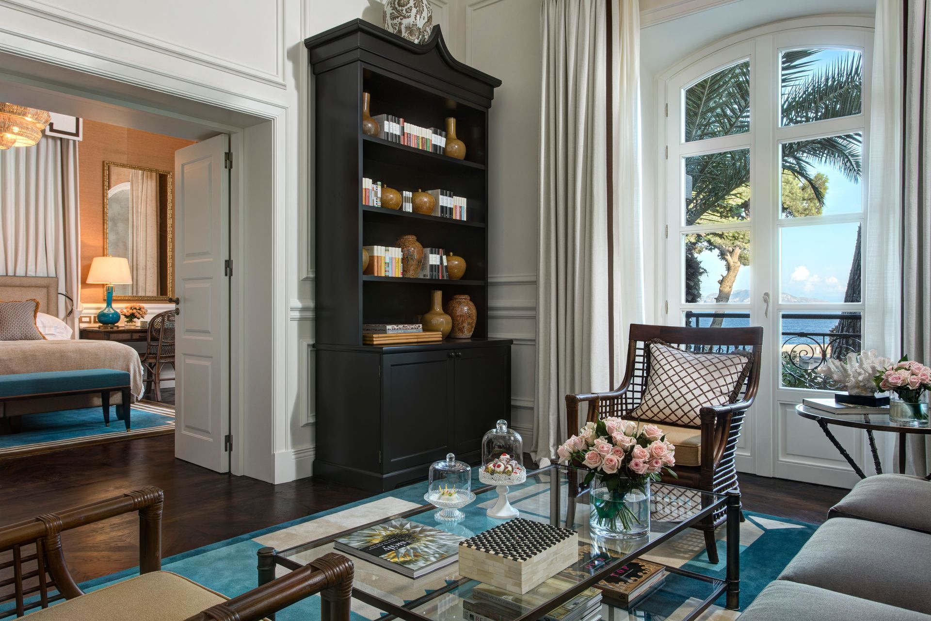 A living room with a couch , chairs , a coffee table and a bookshelf.