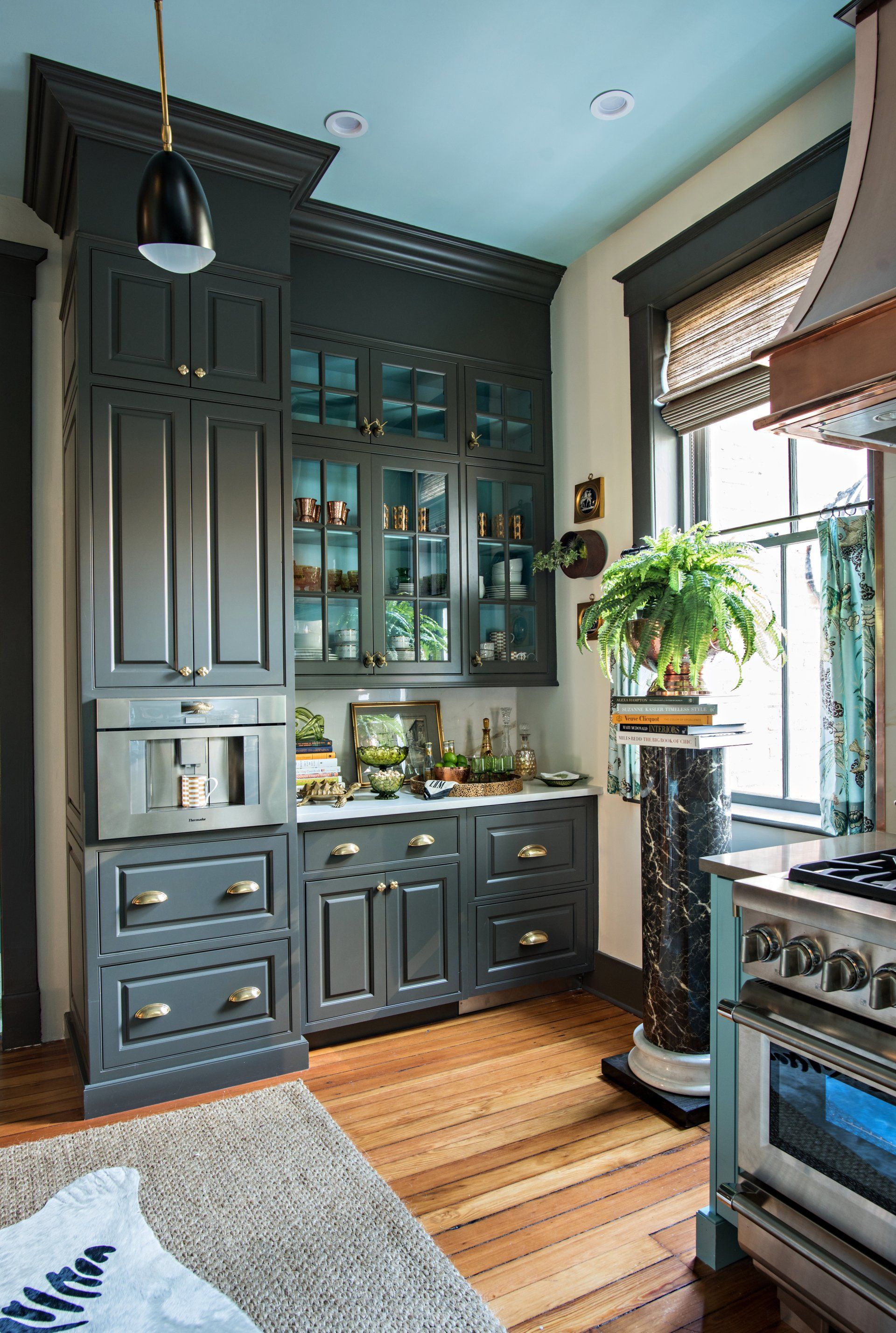 A kitchen with gray cabinets and a blue ceiling.