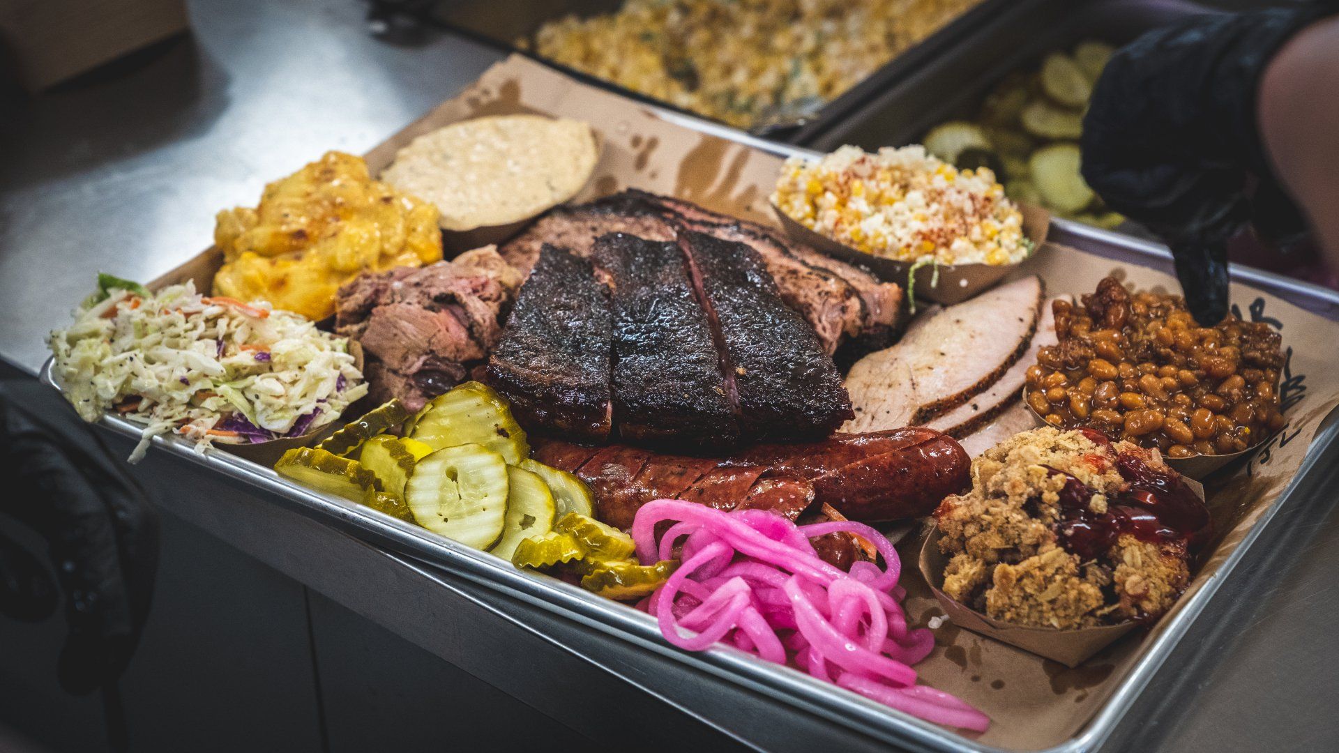 A tray filled with lots of meat and vegetables on a table.