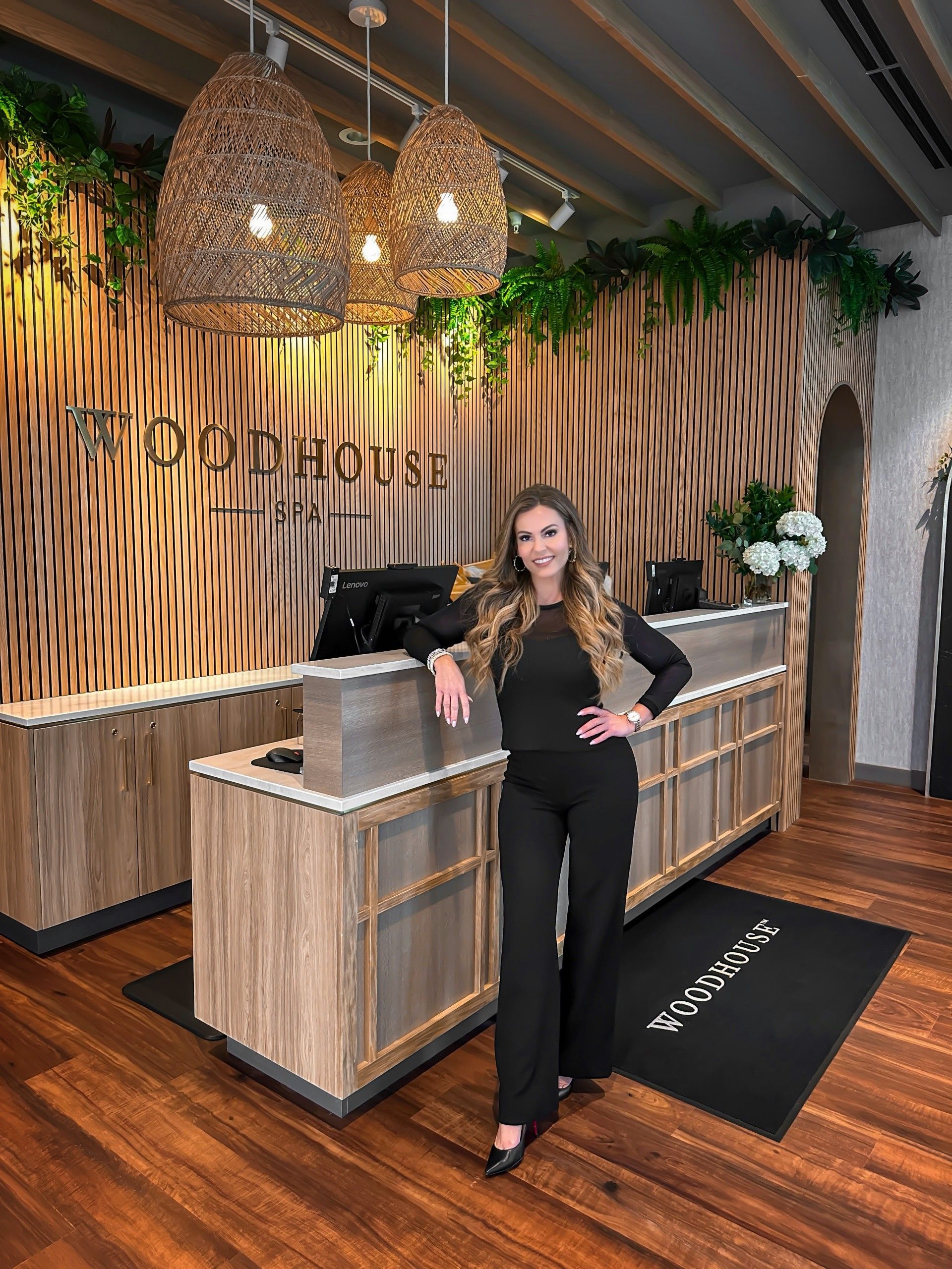 A woman is standing in front of a reception desk in a restaurant.