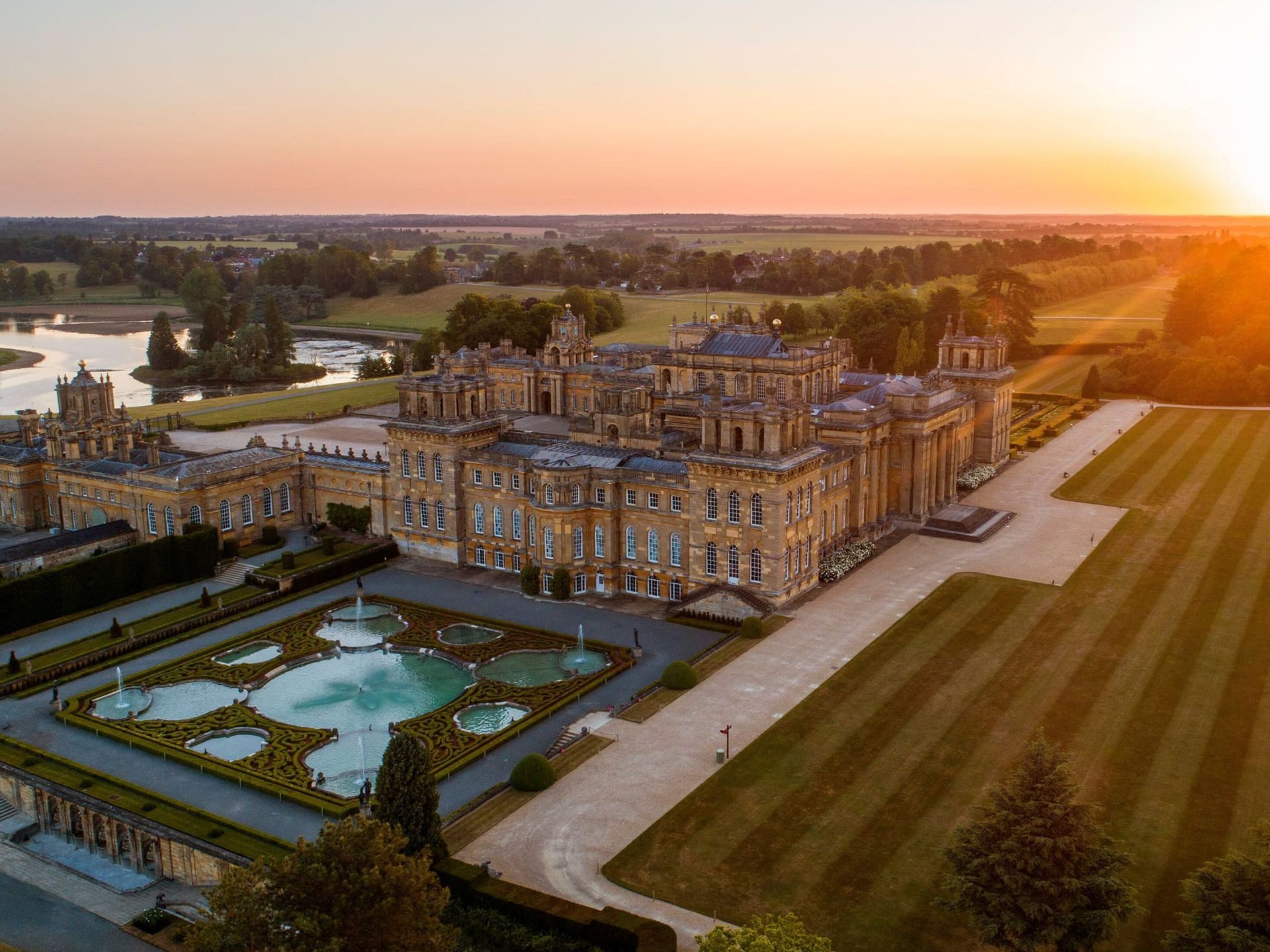 An aerial view of a large castle at sunset.