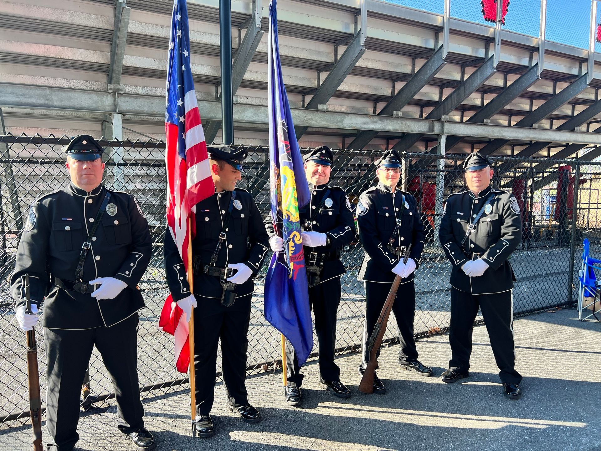 A group of police officers standing next to each other holding flags.