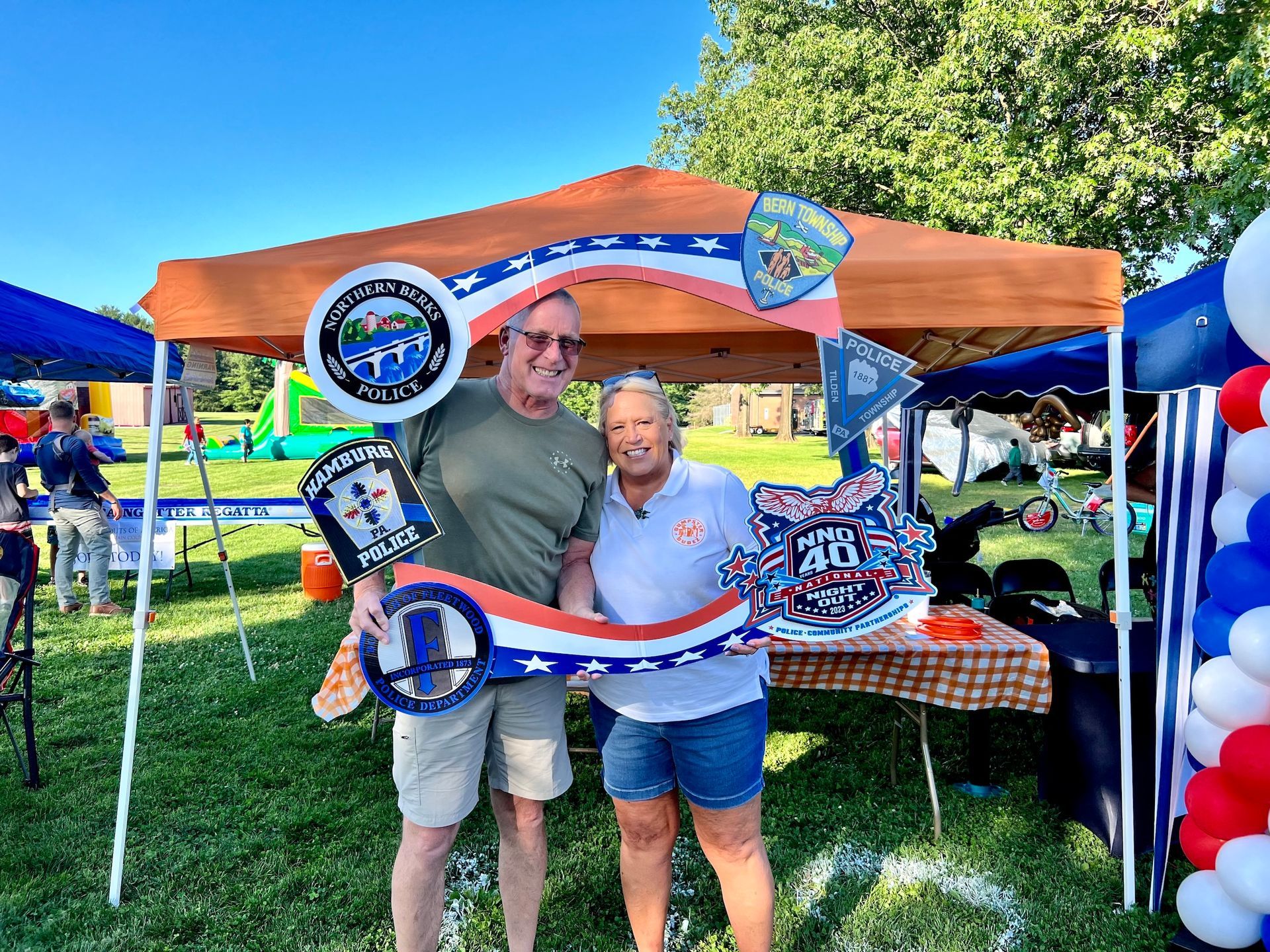 A man and a woman are posing for a picture in front of a tent.