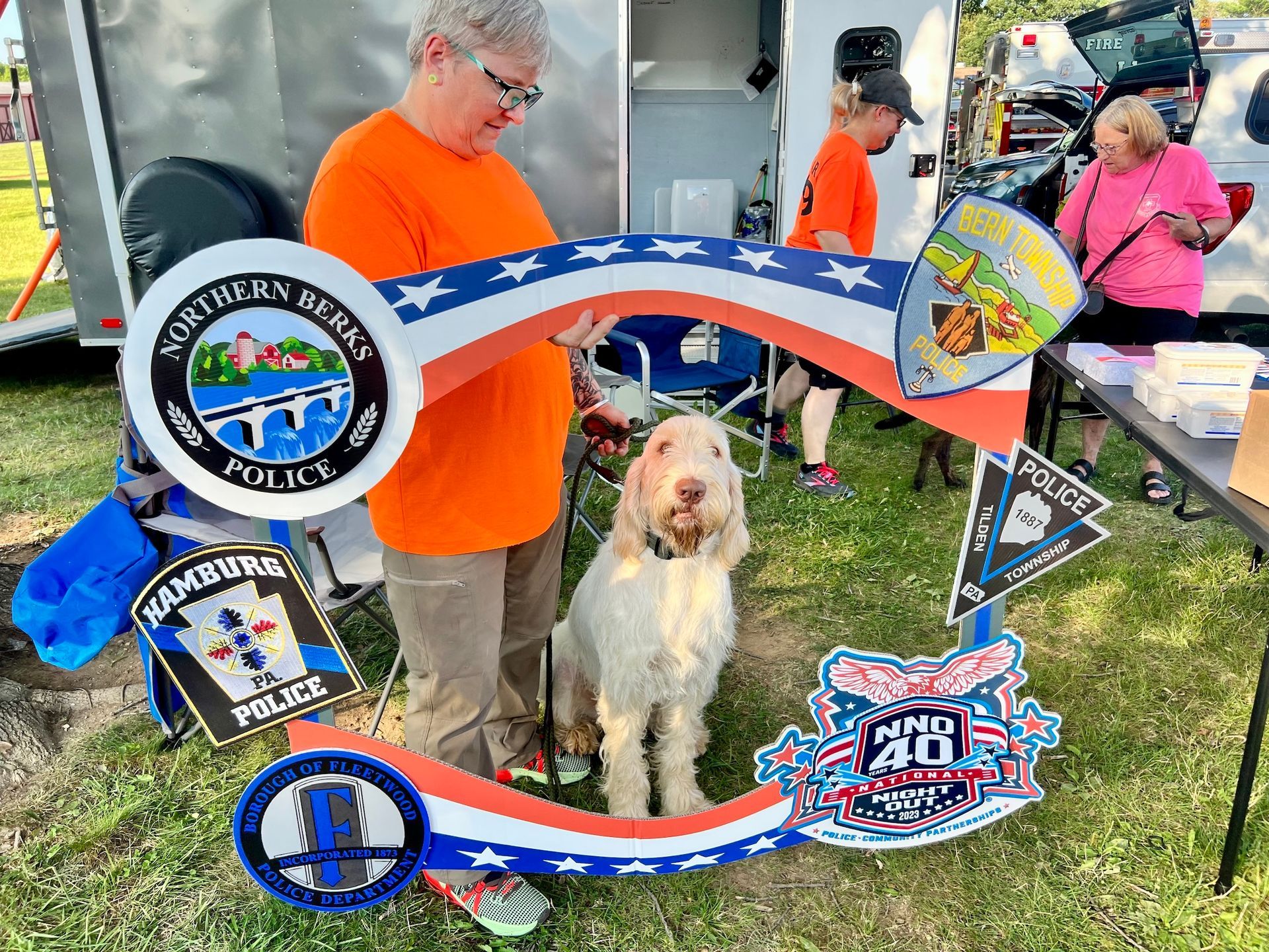 A woman is holding a picture frame with a dog in it.